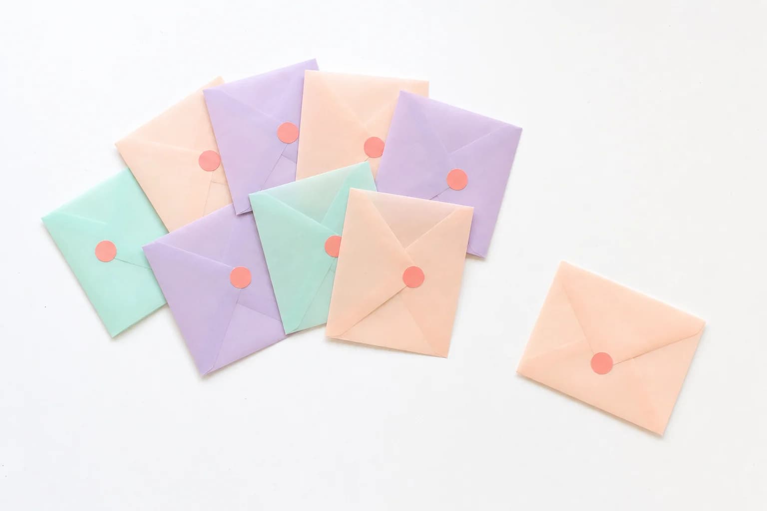 A fan of sealed pastel envelopes, one set apart from the rest